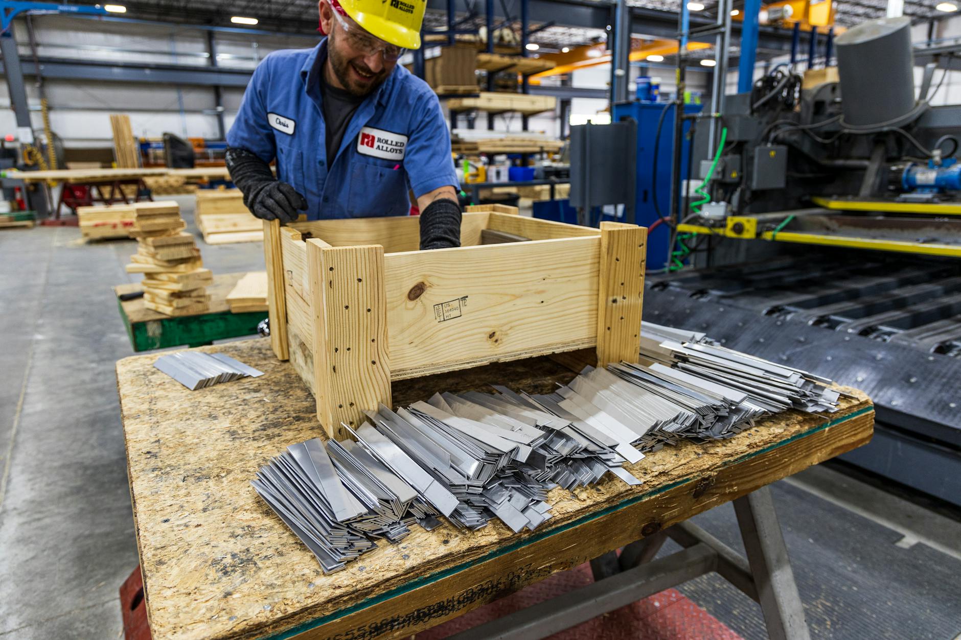 Two craftsmen discussing woodworking plans in a busy workshop